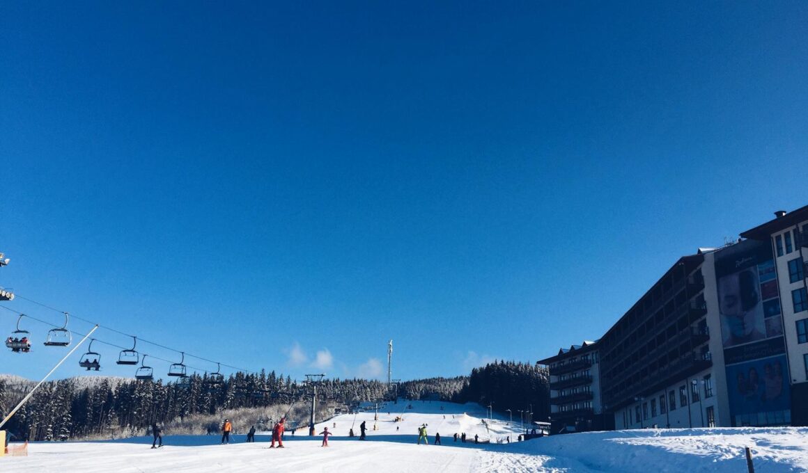 People on a Snowy Ski Hill With a Lift on the Left and a Hotel on the Right