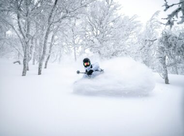 person riding on black motorcycle on snow covered ground during daytime